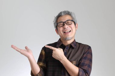 Beyaz arka planda duran kıdemli Asyalı adam.