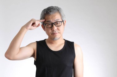 Beyaz arka planda duran spor üniformalı yaşlı Asyalı adam..