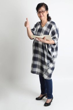 Beyaz arka planda duran yaşlı Asyalı kadın..