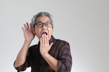 Beyaz arka planda duran kıdemli Asyalı adam.