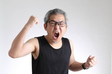 Beyaz arka planda duran spor üniformalı yaşlı Asyalı adam..