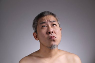 Gri arka planda Asyalı bir adamın portresi..