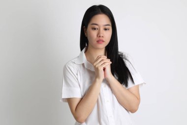 Üniversite üniformalı Asyalı kız beyaz arka planda duruyor..