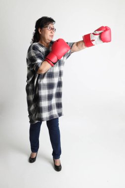 Beyaz arka planda duran yaşlı Asyalı kadın..