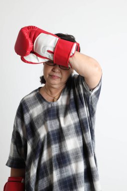 Beyaz arka planda duran yaşlı Asyalı kadın..