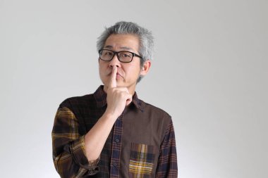 Beyaz arka planda duran kıdemli Asyalı adam.