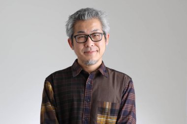 Beyaz arka planda duran kıdemli Asyalı adam.