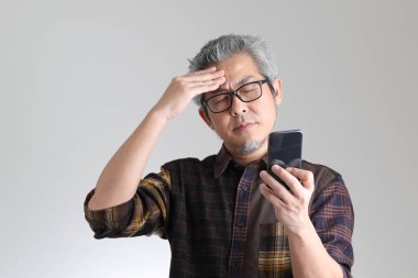 Beyaz arka planda duran kıdemli Asyalı adam.