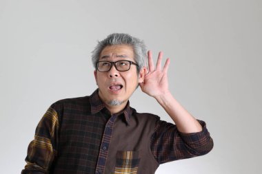 Beyaz arka planda duran kıdemli Asyalı adam.