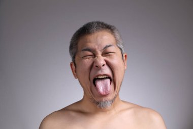 Gri arka planda Asyalı bir adamın portresi..