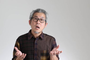 Beyaz arka planda duran kıdemli Asyalı adam.