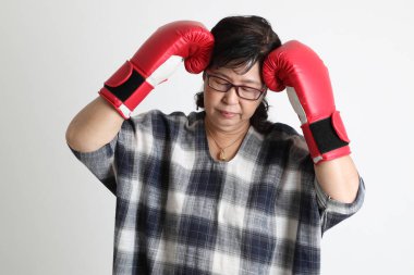 Beyaz arka planda duran yaşlı Asyalı kadın..