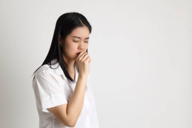 Üniversite üniformalı Asyalı kız beyaz arka planda duruyor..