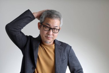 Beyaz arka planda duran akıllı Asyalı adam..