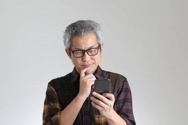 Beyaz arka planda duran kıdemli Asyalı adam.