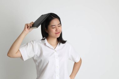 Üniversite üniformalı Asyalı kız beyaz arka planda duruyor..