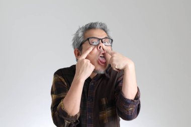 Beyaz arka planda duran kıdemli Asyalı adam.