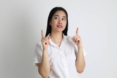 Üniversite üniformalı Asyalı kız beyaz arka planda duruyor..