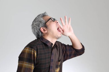 Beyaz arka planda duran kıdemli Asyalı adam.