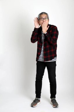 Beyaz arka planda duran Asyalı adam.