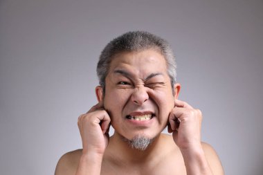 Gri arka planda Asyalı bir adamın portresi..