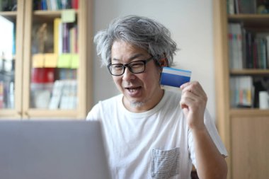 Asyalı adam internetten alışveriş yapıyor..