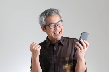 Beyaz arka planda duran kıdemli Asyalı adam.