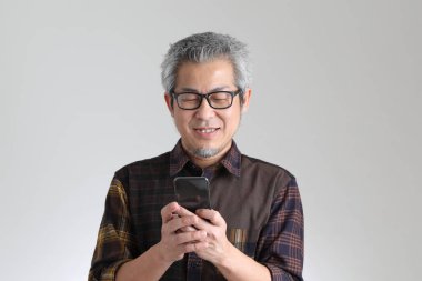 Beyaz arka planda duran kıdemli Asyalı adam.