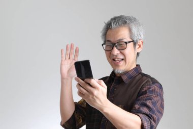 Beyaz arka planda duran kıdemli Asyalı adam.