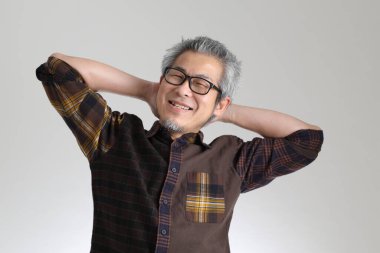 Beyaz arka planda duran kıdemli Asyalı adam.