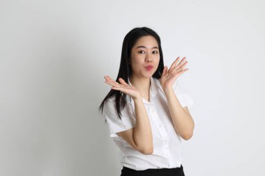 Üniversite üniformalı Asyalı kız beyaz arka planda duruyor..