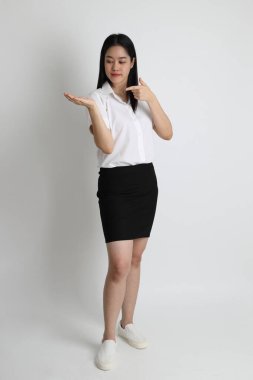 Üniversite üniformalı Asyalı kız beyaz arka planda duruyor..