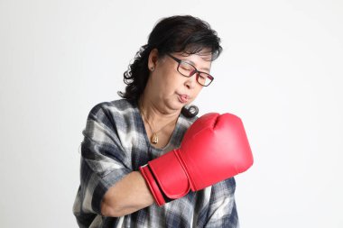 Beyaz arka planda duran yaşlı Asyalı kadın..