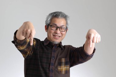 Beyaz arka planda duran kıdemli Asyalı adam.