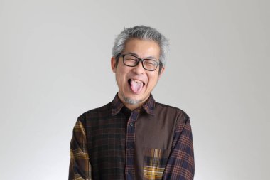 Beyaz arka planda duran kıdemli Asyalı adam.