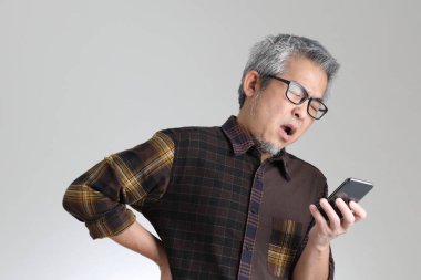 Beyaz arka planda duran kıdemli Asyalı adam.