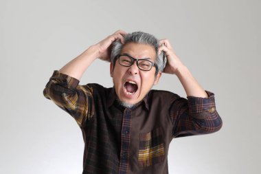 Beyaz arka planda duran kıdemli Asyalı adam.