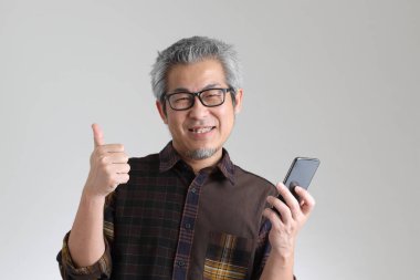 Beyaz arka planda duran kıdemli Asyalı adam.