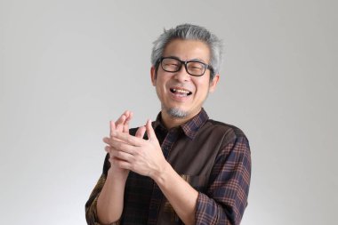 Beyaz arka planda duran kıdemli Asyalı adam.