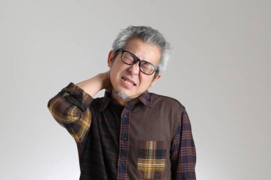 Beyaz arka planda duran kıdemli Asyalı adam.