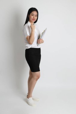 Üniversite üniformalı Asyalı kız beyaz arka planda duruyor..