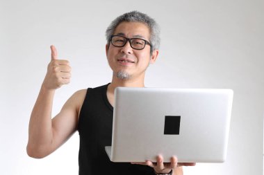 Beyaz arka planda duran spor üniformalı yaşlı Asyalı adam..