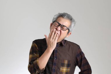 Beyaz arka planda duran kıdemli Asyalı adam.