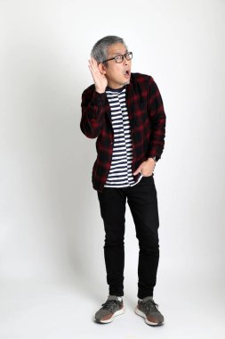 Beyaz arka planda duran Asyalı adam.