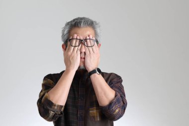 Beyaz arka planda duran kıdemli Asyalı adam.