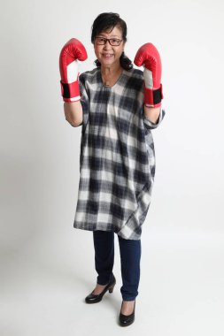 Beyaz arka planda duran yaşlı Asyalı kadın..