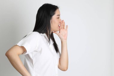 Üniversite üniformalı Asyalı kız beyaz arka planda duruyor..