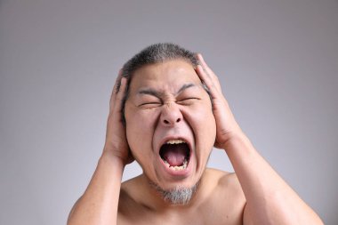 Gri arka planda Asyalı bir adamın portresi..