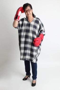 Beyaz arka planda duran yaşlı Asyalı kadın..