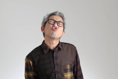 Beyaz arka planda duran kıdemli Asyalı adam.